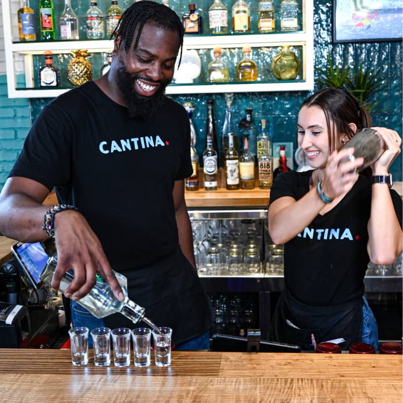 Bar staff pouring drinks.